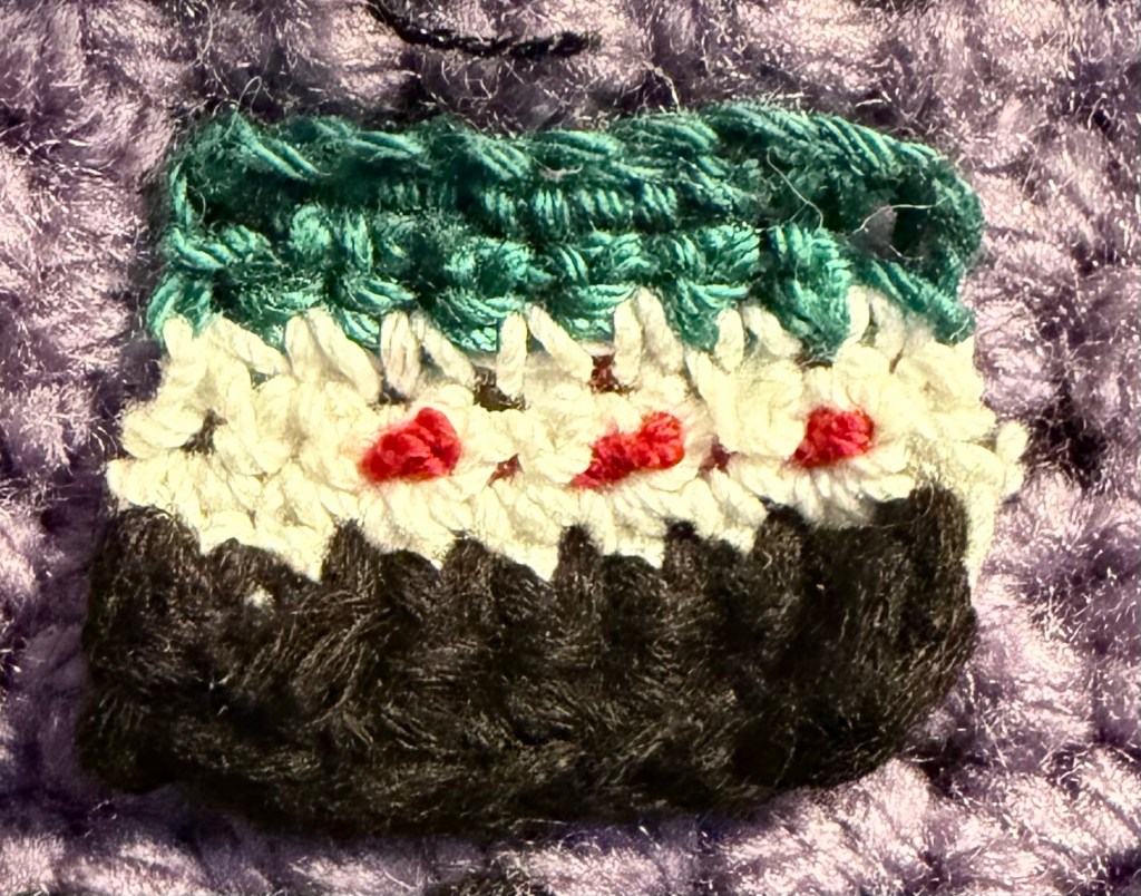 crocheted miniature of Syrian flag
